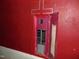 A red electrical panel with exposed wiring and a stained wall at 223 S Main St, Wendell, NC 27591