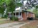 Quaint brick home with a screened porch, mature trees, and a classic design at 223 S Main St, Wendell, NC 27591