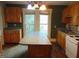 Kitchen featuring wooden cabinets, white appliances, and a center island at 223 S Main St, Wendell, NC 27591