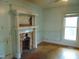 Room with hardwood floors, fireplace with decorative mantle, and natural light from a window at 223 S Main St, Wendell, NC 27591