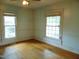 Light-filled room with hardwood floors and two large windows, offering views of the neighborhood at 223 S Main St, Wendell, NC 27591