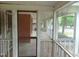 Screened in front porch shows a brick column, white railings, and yard views at 223 S Main St, Wendell, NC 27591