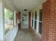 Covered front porch featuring brick columns, white railings and view of yard at 223 S Main St, Wendell, NC 27591