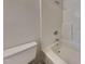 Clean bathroom featuring a toilet and a bathtub-shower combination with white tile surround at 2428 Diquedo Dr, Raleigh, NC 27604