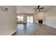 Bright living room featuring wood floors, a fireplace, ceiling fan, and access to the backyard at 2428 Diquedo Dr, Raleigh, NC 27604