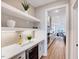 Wet bar with beverage cooler, quartz countertops, shelving, and modern backsplash is adjacent to the kitchen at 2437 Terri Creek Dr, Fuquay Varina, NC 27526