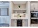Bar area with beverage cooler, quartz countertops, shelving, and modern backsplash near stainless steel appliances at 2437 Terri Creek Dr, Fuquay Varina, NC 27526