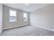 Bright bedroom with plush carpet, two windows allowing ample natural light, and neutral color palette at 2437 Terri Creek Dr, Fuquay Varina, NC 27526