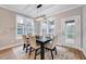 Dining area boasts a modern light fixture, natural light, table with seating for six, and backyard views at 2437 Terri Creek Dr, Fuquay Varina, NC 27526