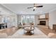 Comfortable living room with a stone fireplace, large windows, and a ceiling fan at 2437 Terri Creek Dr, Fuquay Varina, NC 27526