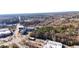 A high-angle aerial view displays a mix of buildings, roads, and lush trees in the area at 2507 Princewood St, Raleigh, NC 27612