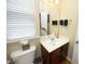 Half bathroom featuring a vanity with dark wood cabinets, a mirror, and natural light from the window at 2507 Princewood St, Raleigh, NC 27612