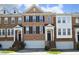 Brick townhome featuring symmetrical design, black shutters, and inviting front entrance with garage at 2507 Princewood St, Raleigh, NC 27612