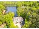 Aerial view of the elegant home with a private lake surrounded by lush greenery and mature trees at 25303 Ludwell, Chapel Hill, NC 27517