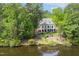 Secluded lakefront home with lush greenery, mature trees, and private waterfront access at 25303 Ludwell, Chapel Hill, NC 27517