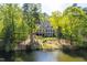 Expansive back exterior of the property, featuring a lush lawn and direct access to the serene lake at 25303 Ludwell, Chapel Hill, NC 27517