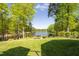 Well-maintained backyard with manicured lawn, lush landscaping, and serene lake view, perfect for relaxation at 25303 Ludwell, Chapel Hill, NC 27517