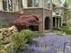 Beautiful backyard with colorful flowers, a charming brick patio, and mature landscaping at 25303 Ludwell, Chapel Hill, NC 27517