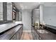 Convenient bar area features sleek gray cabinets with black countertops and a built-in sink for entertaining at 25303 Ludwell, Chapel Hill, NC 27517