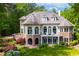 Rear exterior of home features multi-level deck, patio, arched windows, and professionally landscaped garden at 25303 Ludwell, Chapel Hill, NC 27517