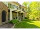 Detailed view of the home's back exterior, highlighting the brick accents, covered patio, and manicured landscaping at 25303 Ludwell, Chapel Hill, NC 27517