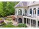 Stunning home exterior boasts a spacious deck, arched windows, and beautiful stone landscaping at 25303 Ludwell, Chapel Hill, NC 27517