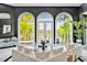 Bright living room features white sofas, black walls, and large arched windows offering stunning views at 25303 Ludwell, Chapel Hill, NC 27517