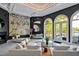 Elegant living room with marble accent wall, modern furniture, and bright, natural light from arched windows at 25303 Ludwell, Chapel Hill, NC 27517