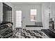 Modern mud room with black and white tile flooring, stylish bench, and sleek, black washer and dryer at 25303 Ludwell, Chapel Hill, NC 27517