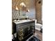 Chic powder room featuring a marble countertop, black vanity, and gold hardware at 25303 Ludwell, Chapel Hill, NC 27517