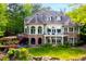 Stunning back exterior featuring a stone patio, landscaped garden, and an expansive deck overlooking a lush backyard at 25303 Ludwell, Chapel Hill, NC 27517