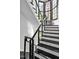 Modern staircase featuring a sleek black and white design with cable railings and large windows for natural light at 25303 Ludwell, Chapel Hill, NC 27517
