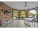 Cozy sunroom features brick walls, arched windows, and peaceful lake views, perfect for relaxing or entertaining guests at 25303 Ludwell, Chapel Hill, NC 27517