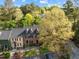 Aerial view of townhomes with dormer windows, black shutters, parking, and lush greenery at 3100 Coachmans Way, Durham, NC 27705