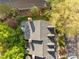 Aerial rooftop view of townhouse with dormer windows, a gray roof, lush trees, and outdoor patio furniture at 3100 Coachmans Way, Durham, NC 27705
