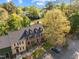 Aerial view of townhomes with dormer windows, black shutters, parking, and lush greenery at 3100 Coachmans Way, Durham, NC 27705
