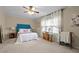 Bright bedroom featuring a ceiling fan, large window, and comfortable queen-sized bed at 3100 Coachmans Way, Durham, NC 27705