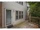 View of a weathered wooden deck and exterior of home with a door and window at 3100 Coachmans Way, Durham, NC 27705