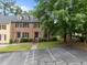 Traditional brick townhouse with dormer windows, mature landscaping, and parking at 3100 Coachmans Way, Durham, NC 27705