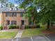 Charming brick townhouse with blue door, manicured landscaping and dormer windows at 3100 Coachmans Way, Durham, NC 27705