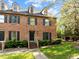 Charming brick townhome featuring dormer windows, black shutters, and a well-manicured front yard at 3100 Coachmans Way, Durham, NC 27705