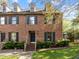 Beautiful brick townhome featuring dormer windows, black shutters, and a manicured lawn at 3100 Coachmans Way, Durham, NC 27705