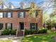 Classic brick townhome featuring dormer windows, black shutters, and a well-kept front lawn at 3100 Coachmans Way, Durham, NC 27705