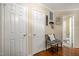 Hallway with a chair and open door leading to a bathroom with wallpaper at 3100 Coachmans Way, Durham, NC 27705