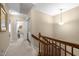 Well-lit upstairs hallway with carpet flooring, wood railing and access to various rooms at 3100 Coachmans Way, Durham, NC 27705