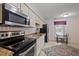 Charming kitchen with granite countertops, black appliances, and an eat-in area at 3100 Coachmans Way, Durham, NC 27705