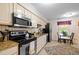 Bright kitchen with stainless steel appliances, tile floor, and eat-in dining area at 3100 Coachmans Way, Durham, NC 27705