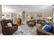 Comfortable living room with leather furniture, patterned rug, and access to the staircase and hallway at 3100 Coachmans Way, Durham, NC 27705