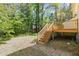 Backyard view featuring a wooden deck with stairs leading to a grassy area and brick path at 3109 E Folkestone Pl, Raleigh, NC 27604