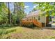 Backyard view of a deck and stairs, complemented by a green lawn and mature trees at 3109 E Folkestone Pl, Raleigh, NC 27604